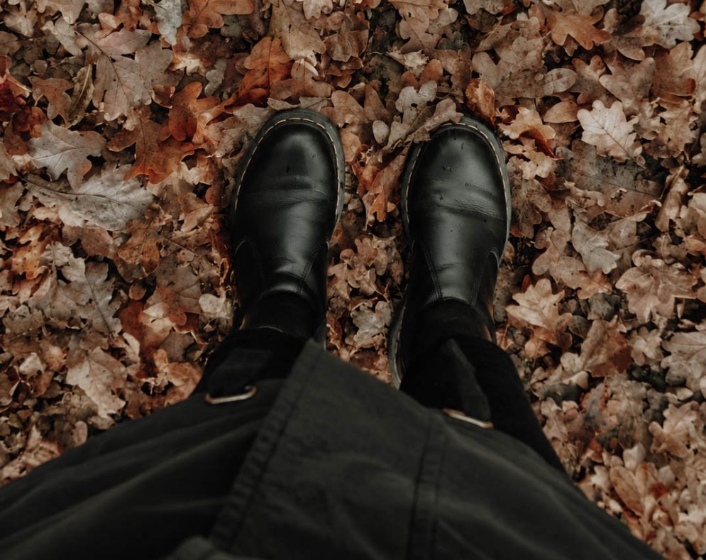 Schwarze Stiefel im braunen Eichenlaub